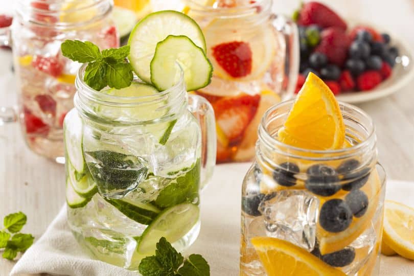 Mason jar glasses filled with various fruit-infused waters.